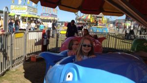 Sisters Lily and Aevryn (our cousins) on a ride at a local carnival back in 2012! August in Traverse City means festivals, concerts, markets, and more! Discover the top events near Dyer Lake Vacation Home.